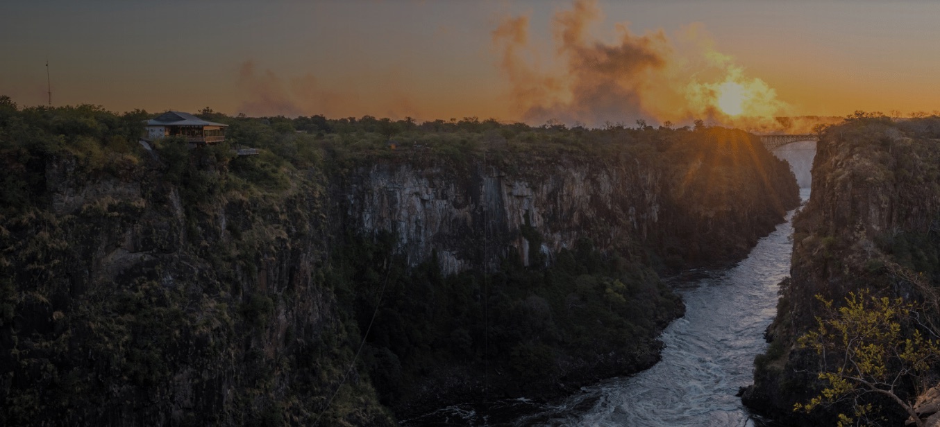 Sunset over the Batoka Gorge below Victoria Falls, with a lodge perched on the cliff edge